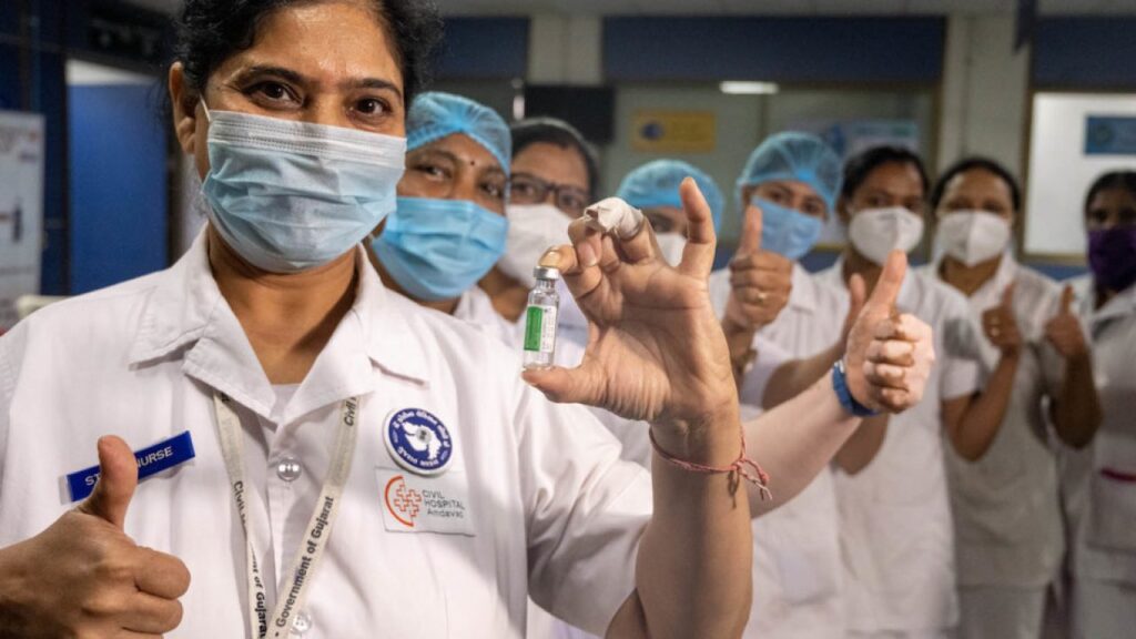 8 Health workers are holding a thumbs up, and are posing with a vial of COVID-19 vaccine after receiving their shots at a hospital in India.