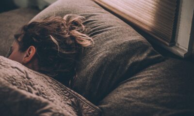 Woman sleeping in bed under the covers with head on pillow.