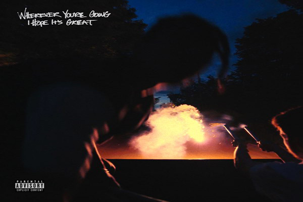 A blurred image of two men holding firecrackers that are exploding into a dark night